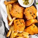 black tray with oven fried fish, French fries and tartar sauce