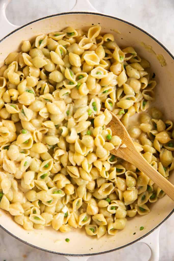 cooked pasta and peas in white skillet