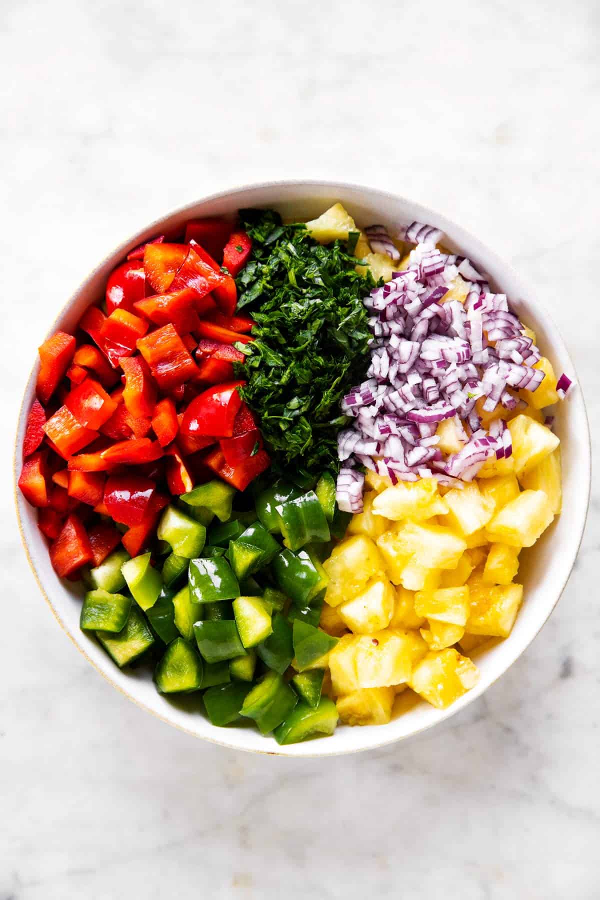 ingredients for pineapple salsa in a white bowl