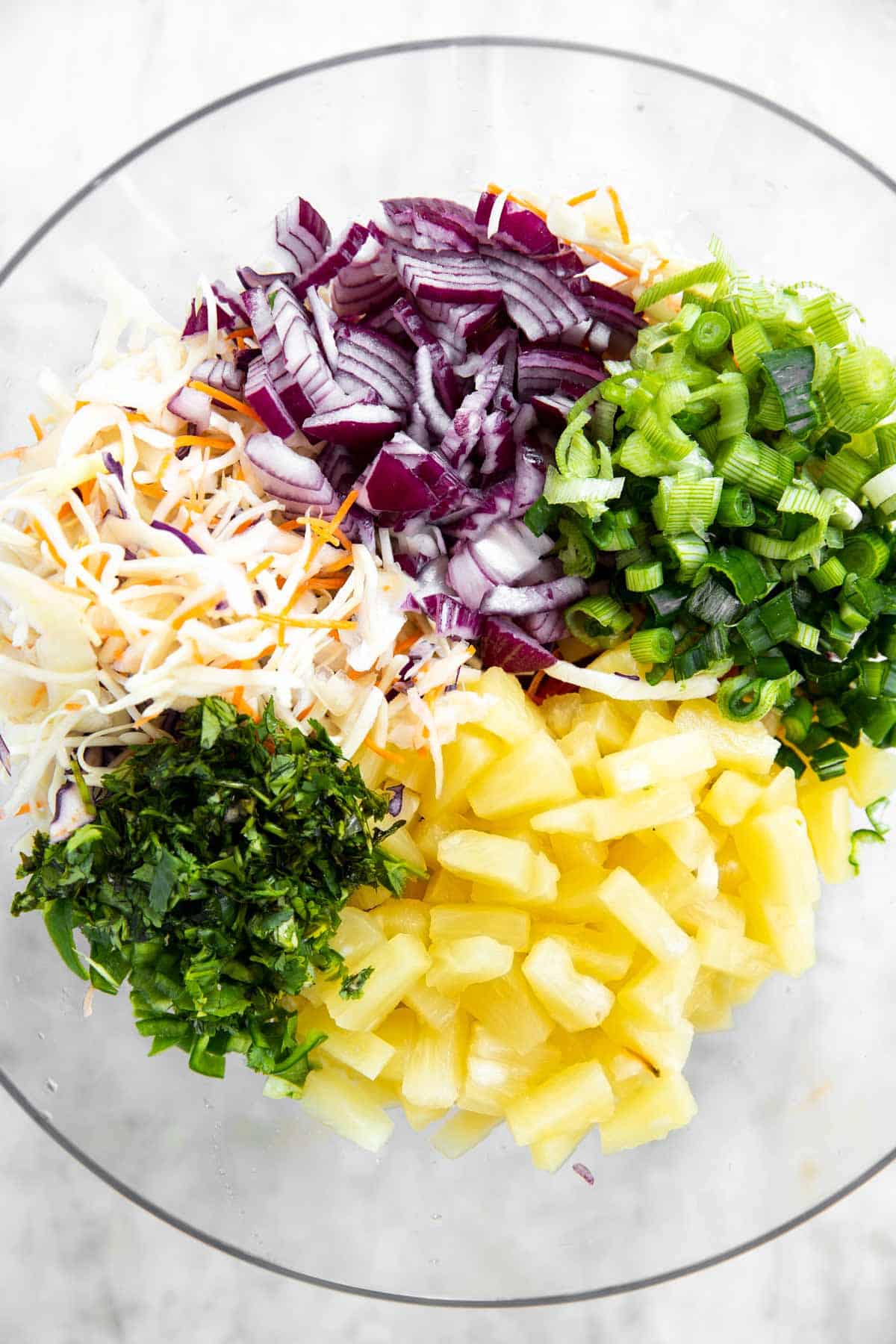 ingredients for pineapple coleslaw in glass bowl