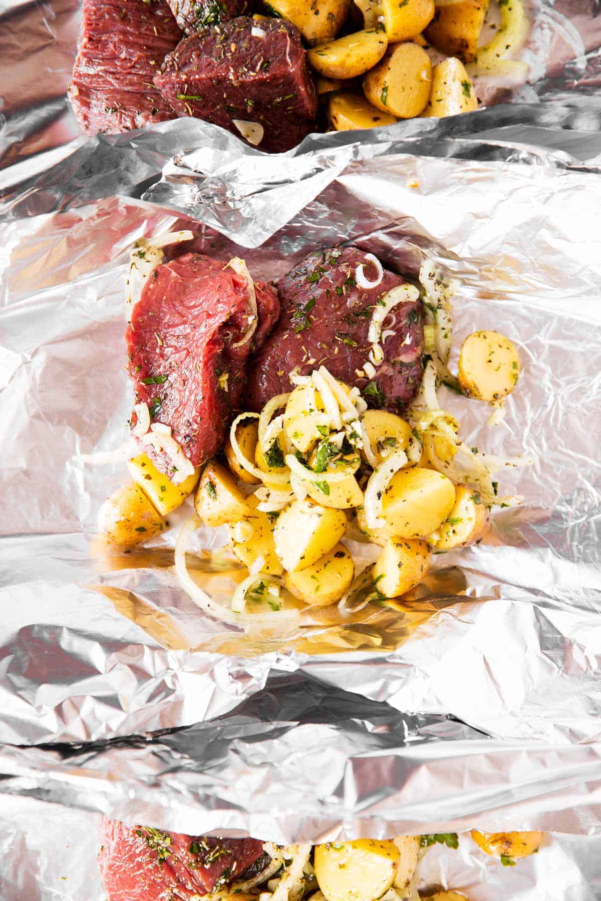 steak and potatoes on piece of aluminum foil