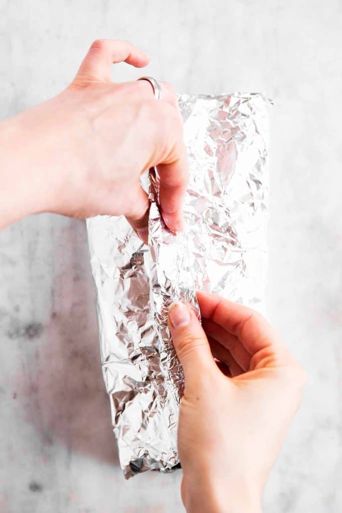 female hands sealing aluminium foil packet