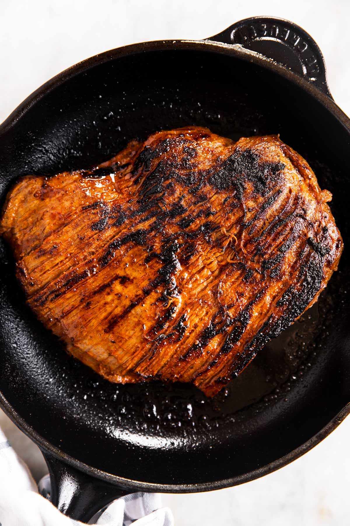 cooked flank steak in cast iron skillet