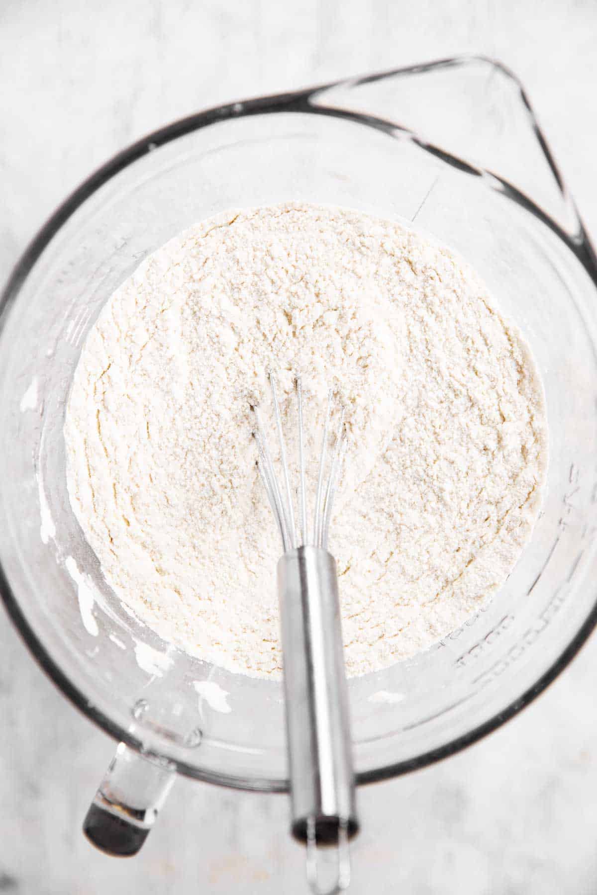 dry ingredients for shortcake biscuits in glass bowl with metal whisk