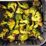 overhead view of roasted broccoli in air fryer basket