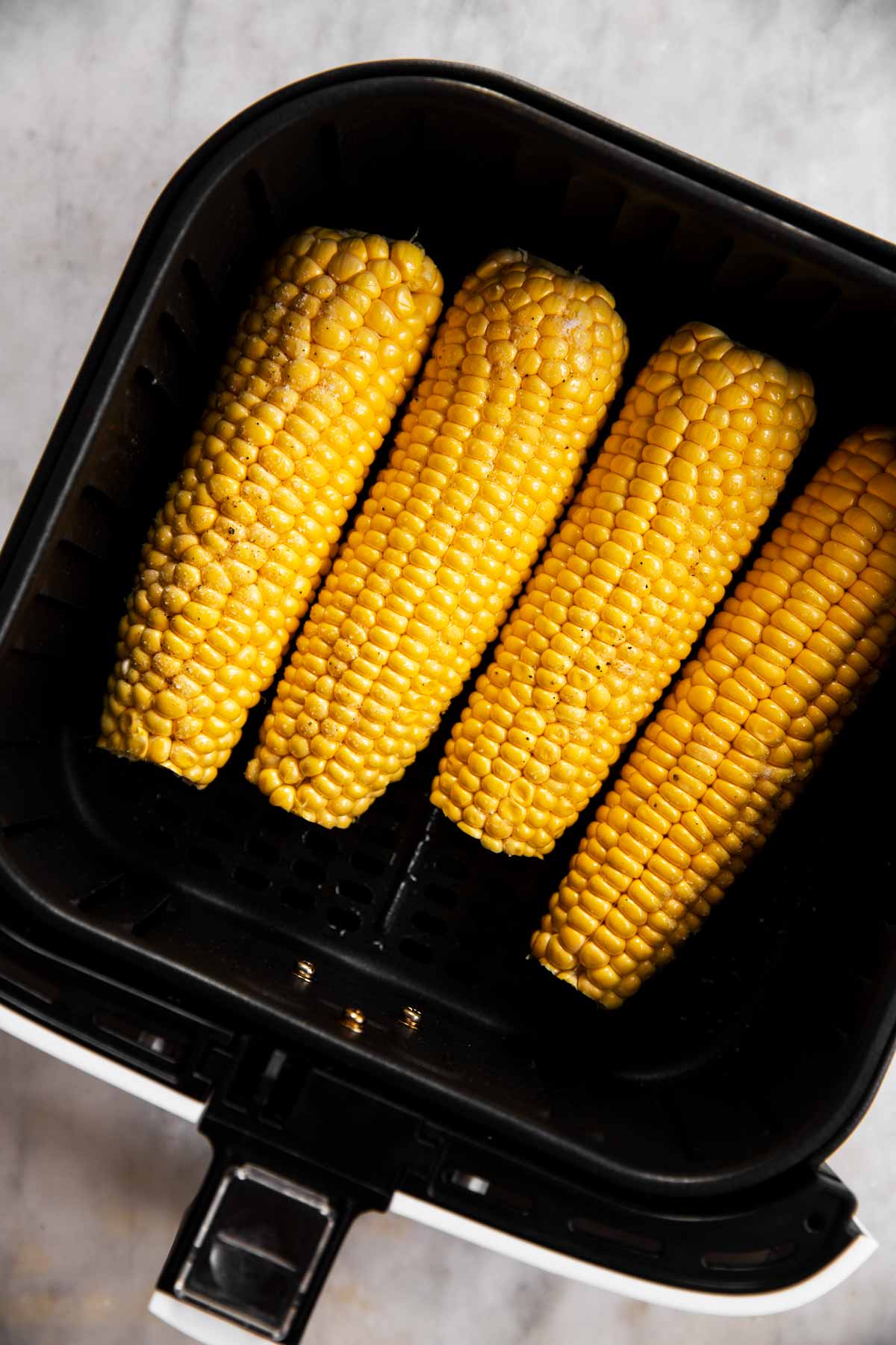 four seasoned ears of corn in air fryer basket