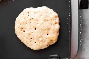 banana pancake ready to be flipped on black griddle