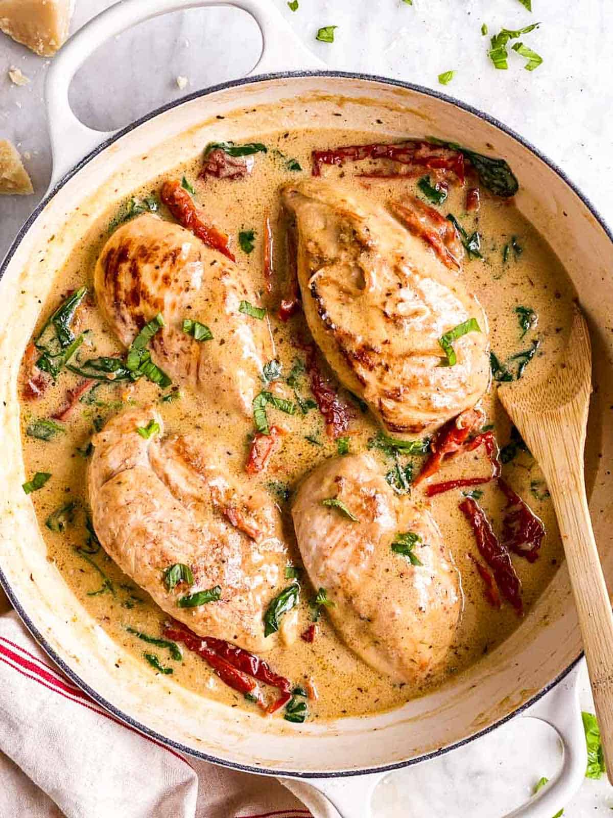 overhead view of tuscan chicken in white cast iron skillet