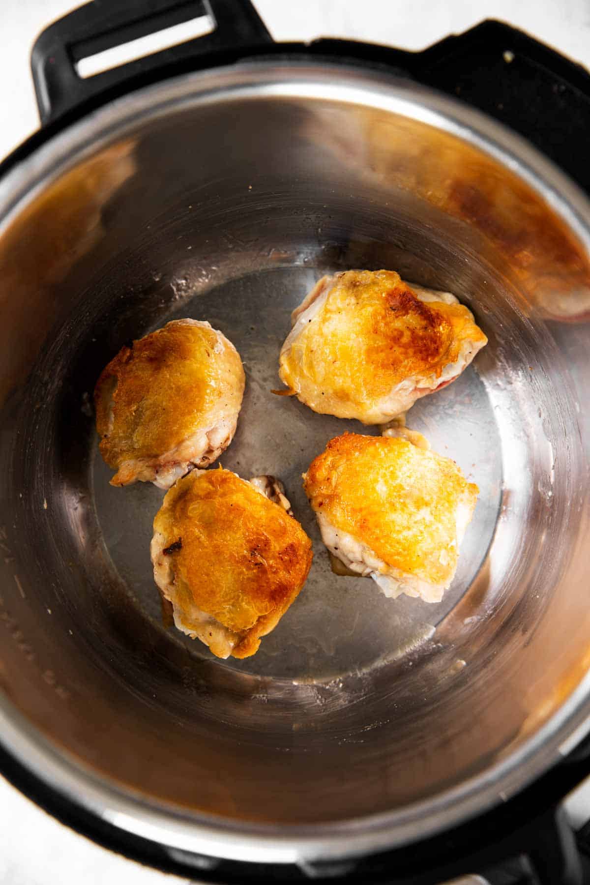 four seared chicken thighs inside instant pot