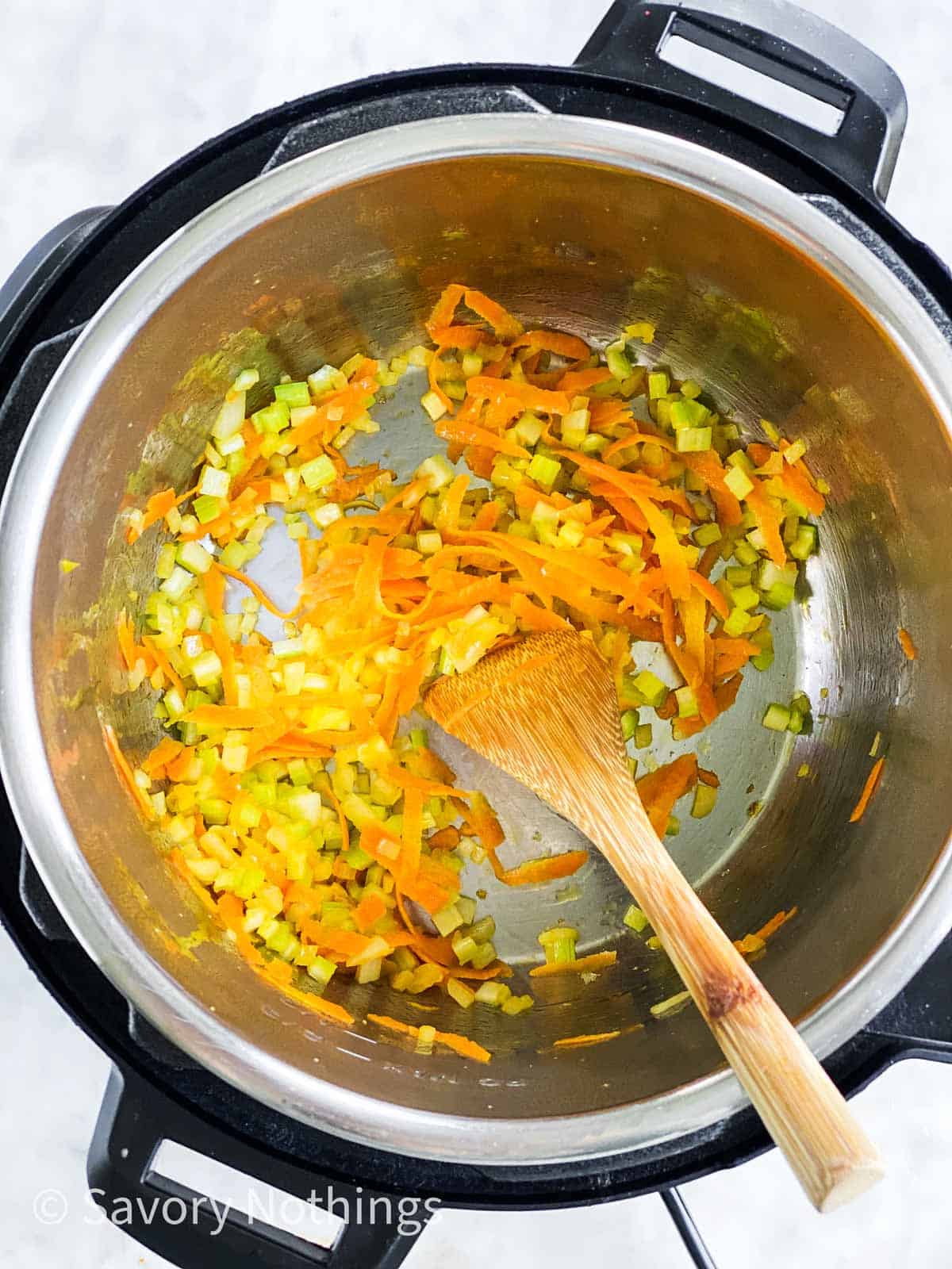 sautéed vegetables in instant pot with wooden spoon