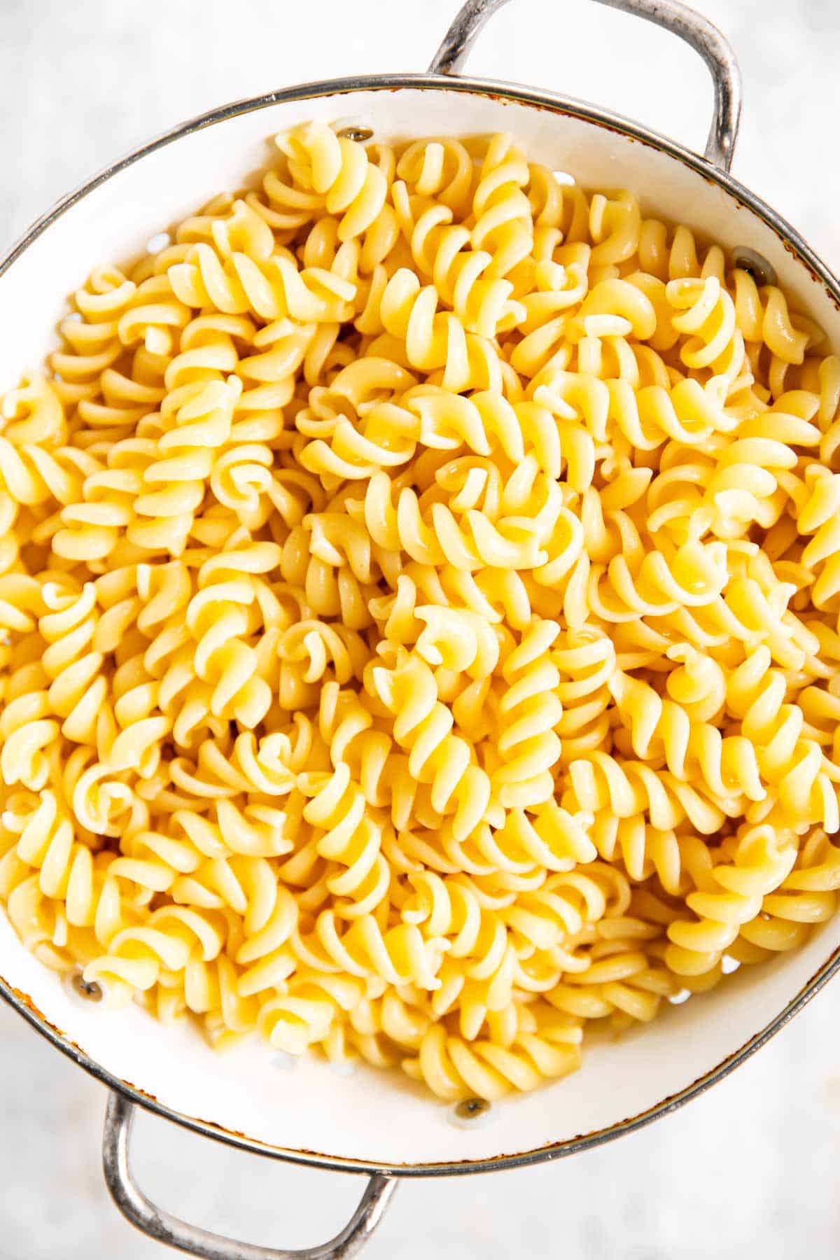 cooked pasta in white colander