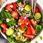 overhead close up view of white bowl with strawberry spinach salad