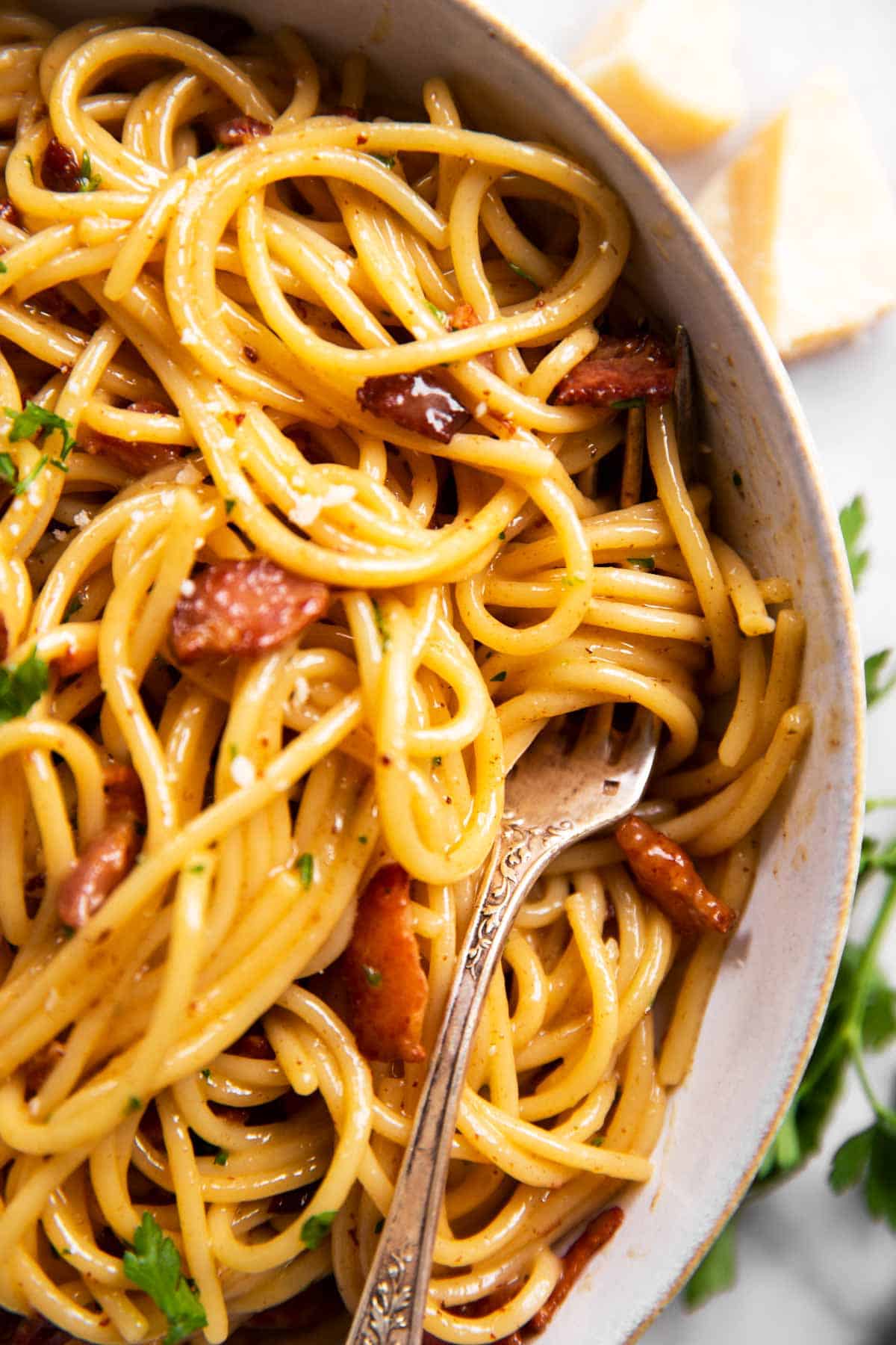 close up photo of fork on white pate with spaghetti carbonara