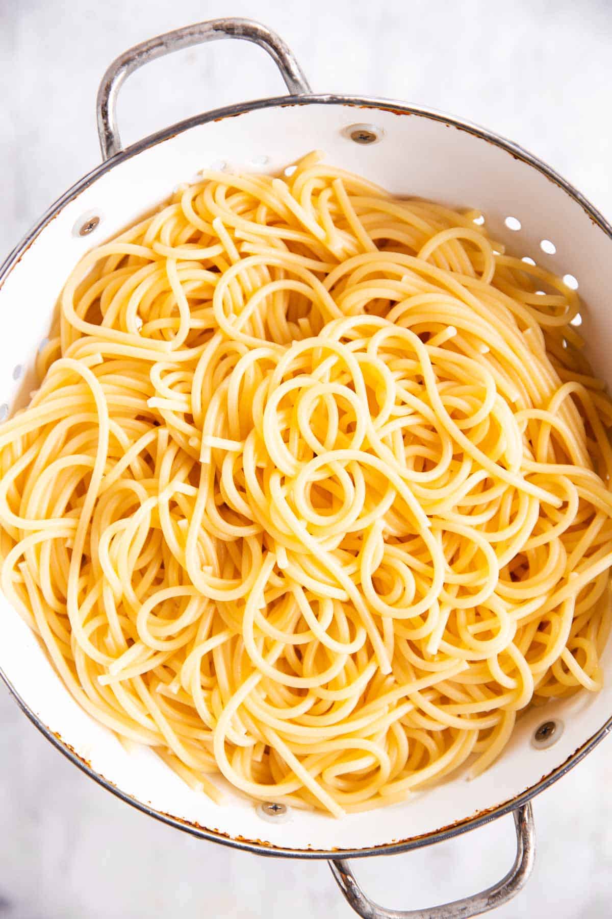 cooked spaghetti in white colander
