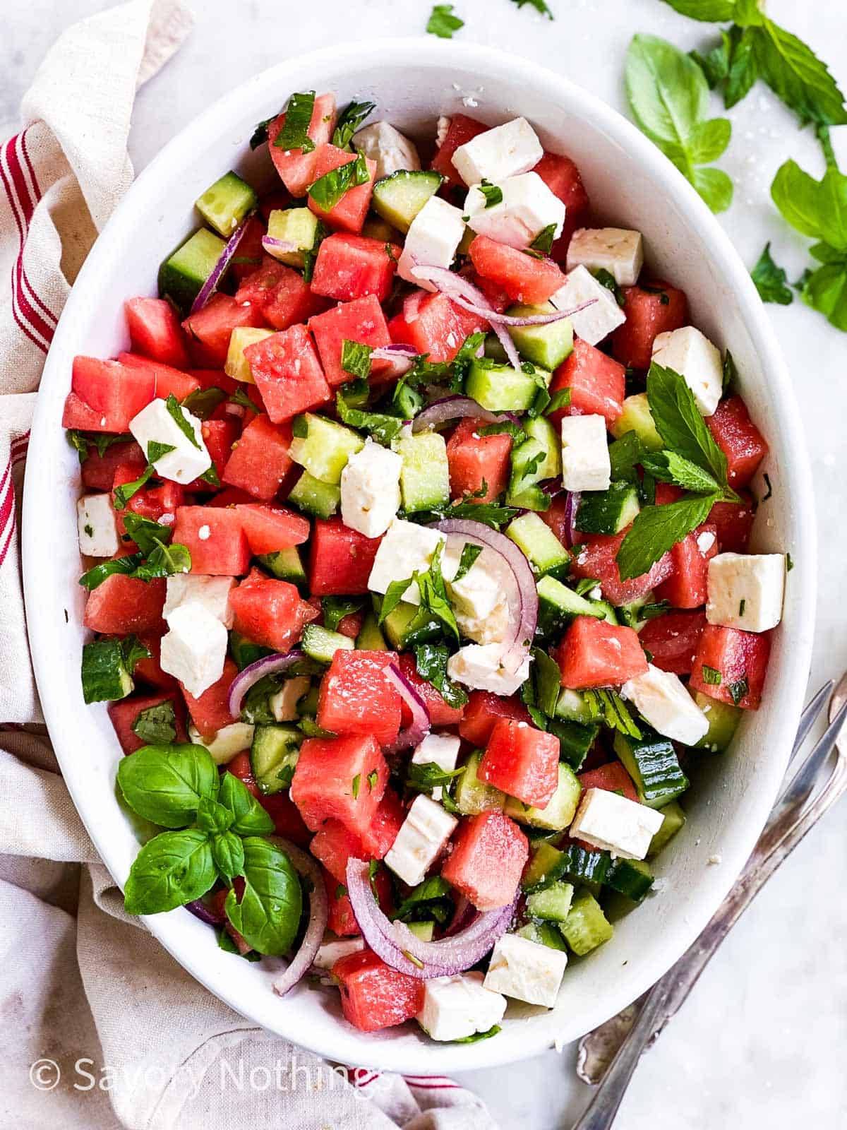 overhead view of watermelon feta salad in oval white dish