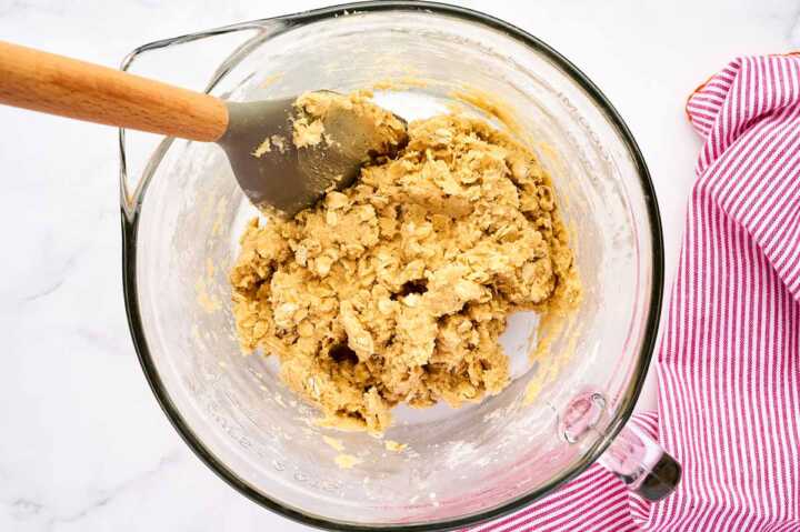 Oatmeal cookie batter in glass bowl.
