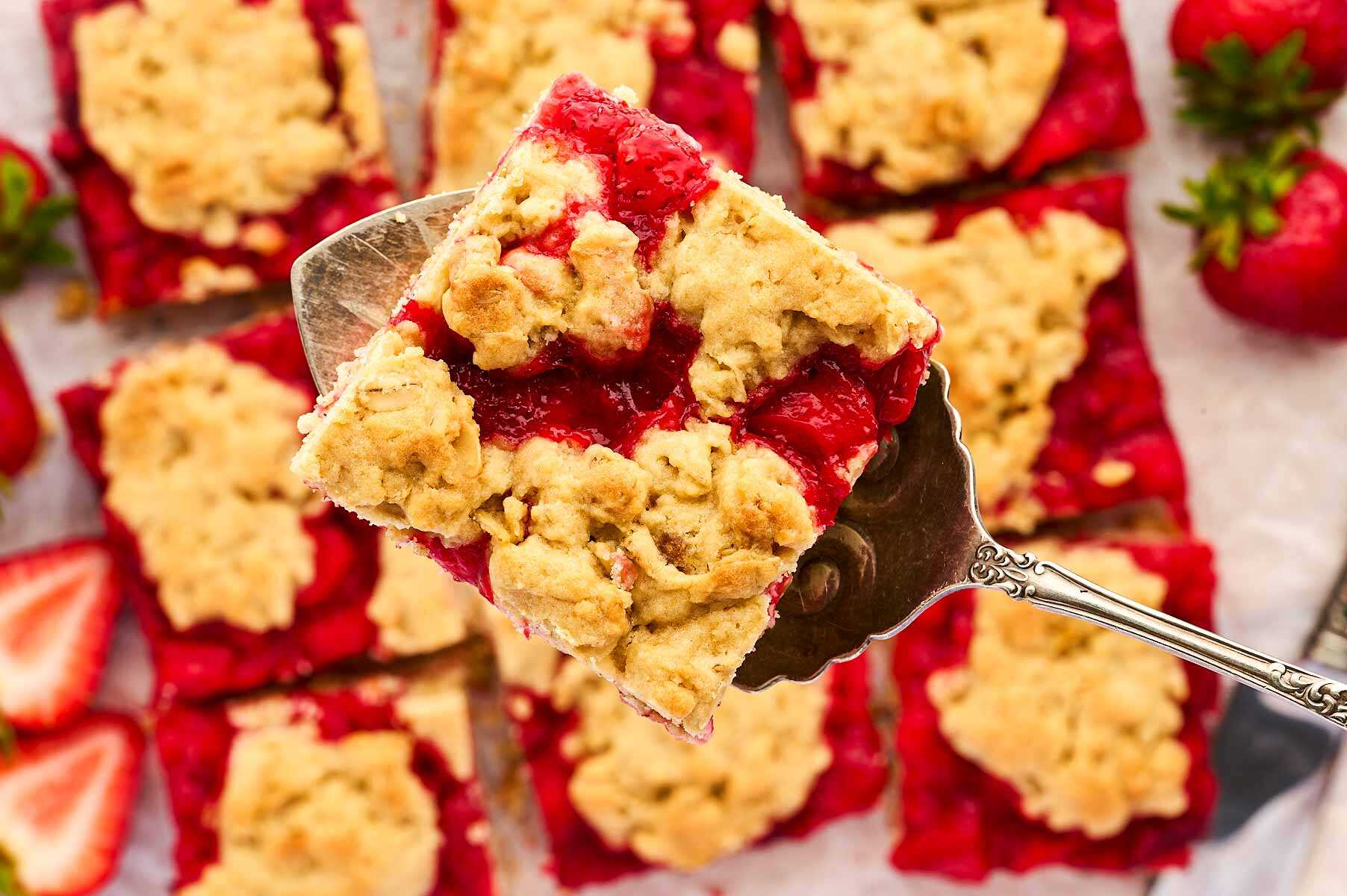 Serving a slice of Strawberry Oatmeal Bars with a cake server.