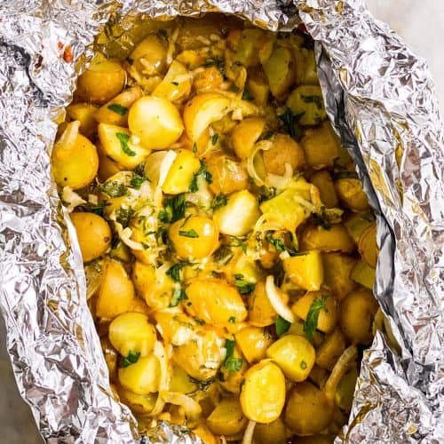 overhead view of cheesy campfire potatoes in foil packet