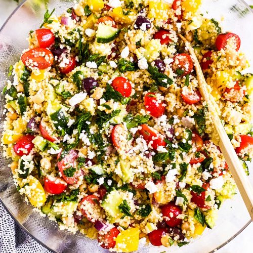 overhead view of glass bowl filled with mediterranean couscous salad