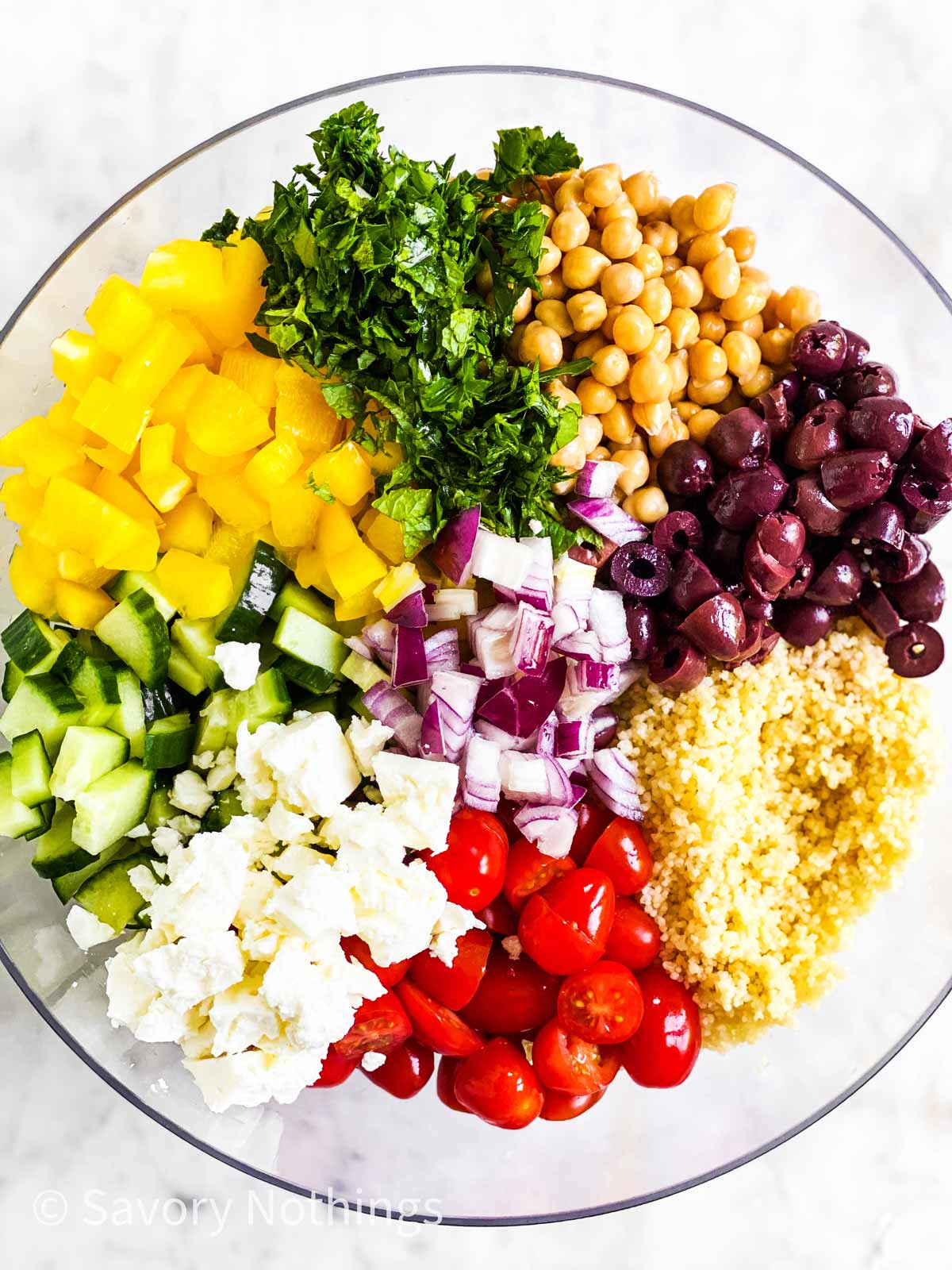 ingredients for couscous salad in glass bowl before mixing