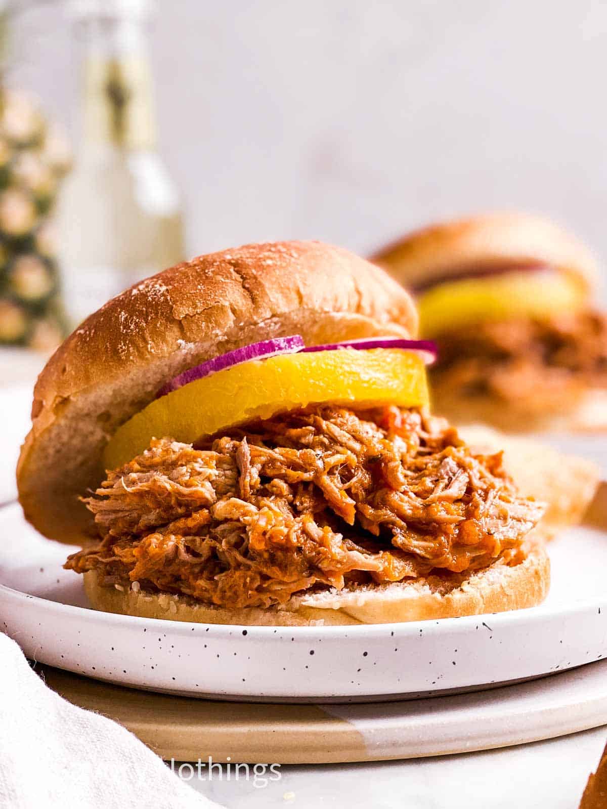 pineapple pulled pork on sandwich bun with canned pineapple ring