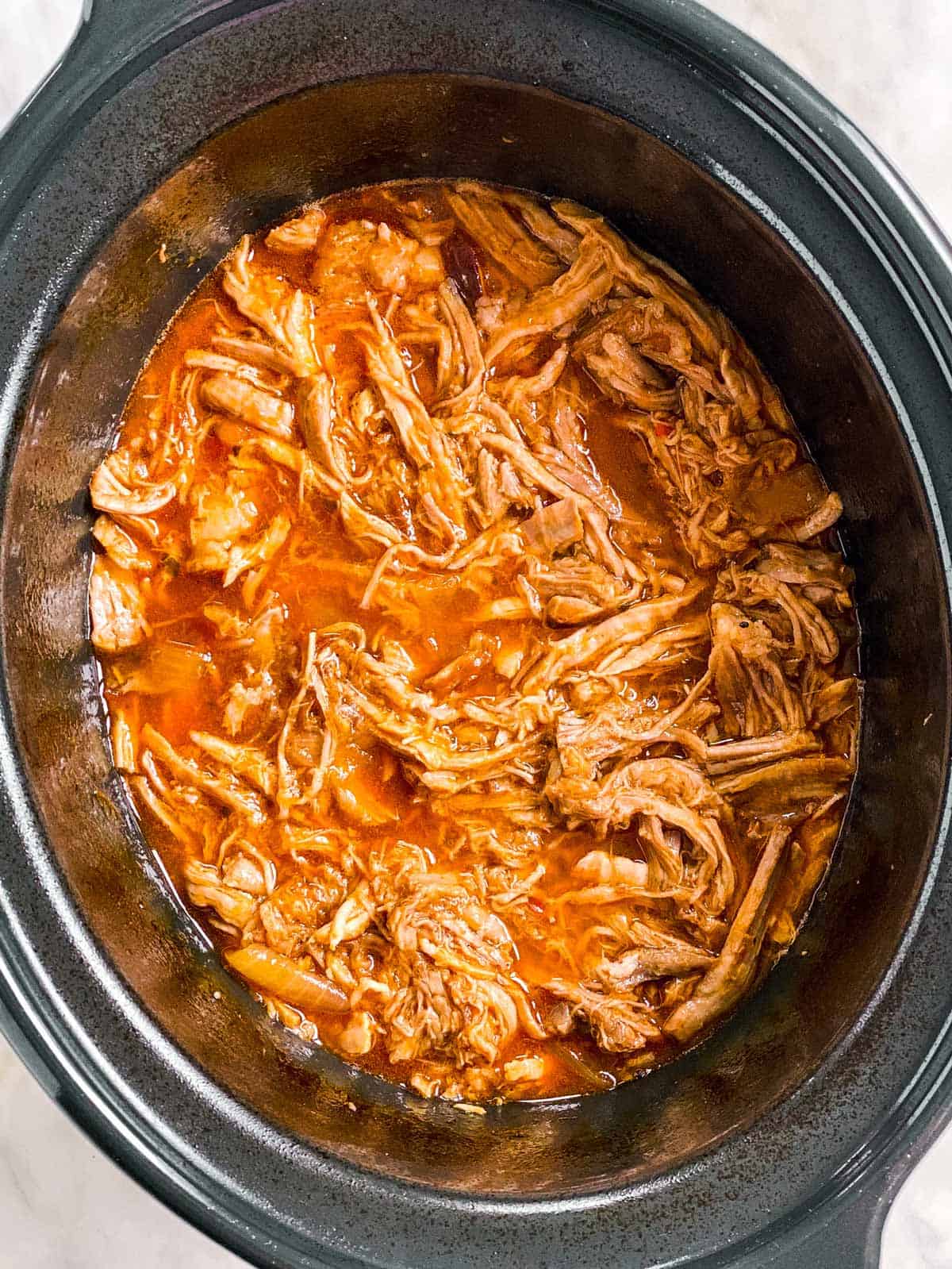 overhead view of pineapple pulled pork in slow cooker
