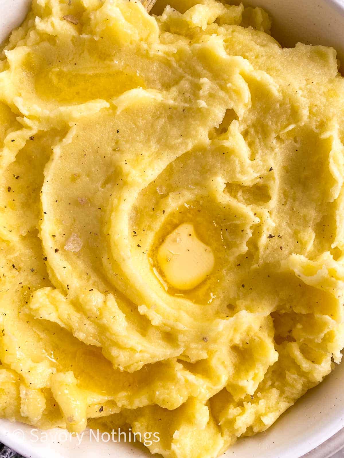 close up photo of instant pot mashed potatoes with pat of butter on top