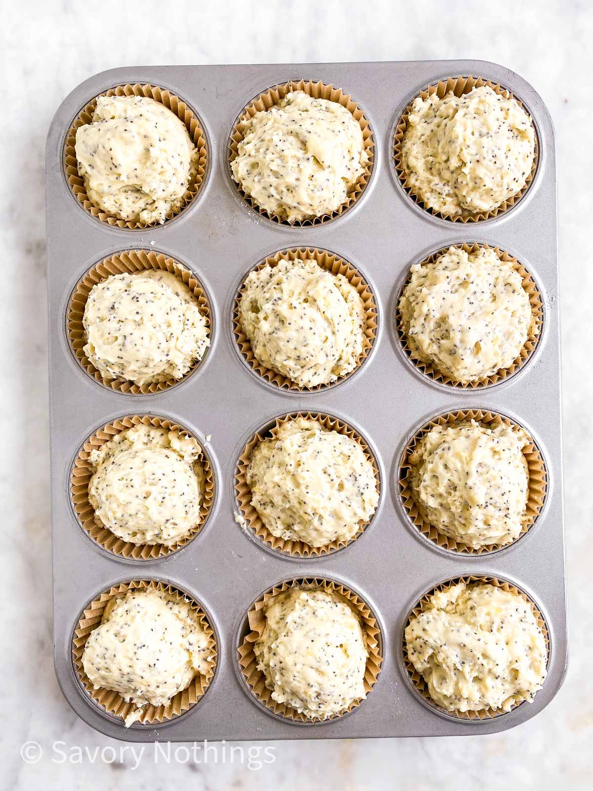 muffin pan with lined cups filled with muffin batter