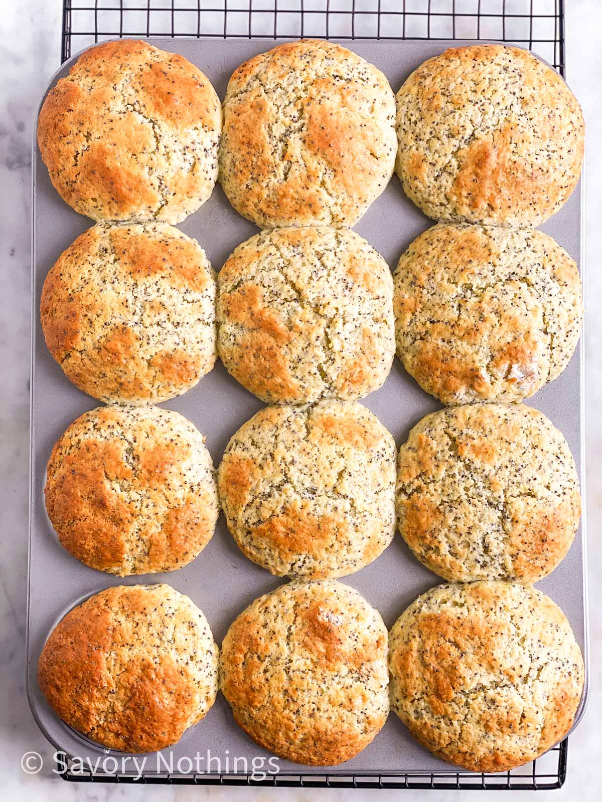 overhead view of muffin pan on cooling rack with baked muffins in cups