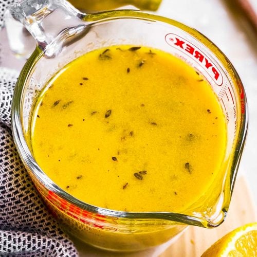 angled overhead view of lemon vinaigrette in glass measuring jug