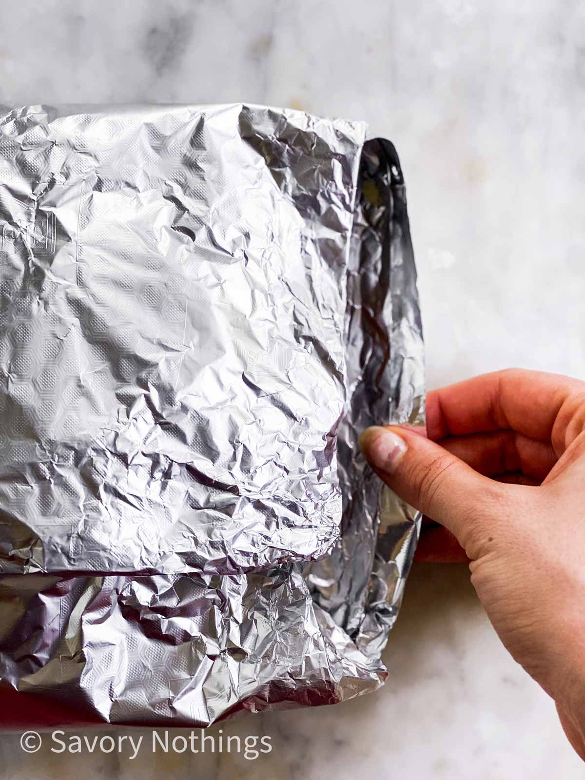 female hand pulling out edge of foil packet