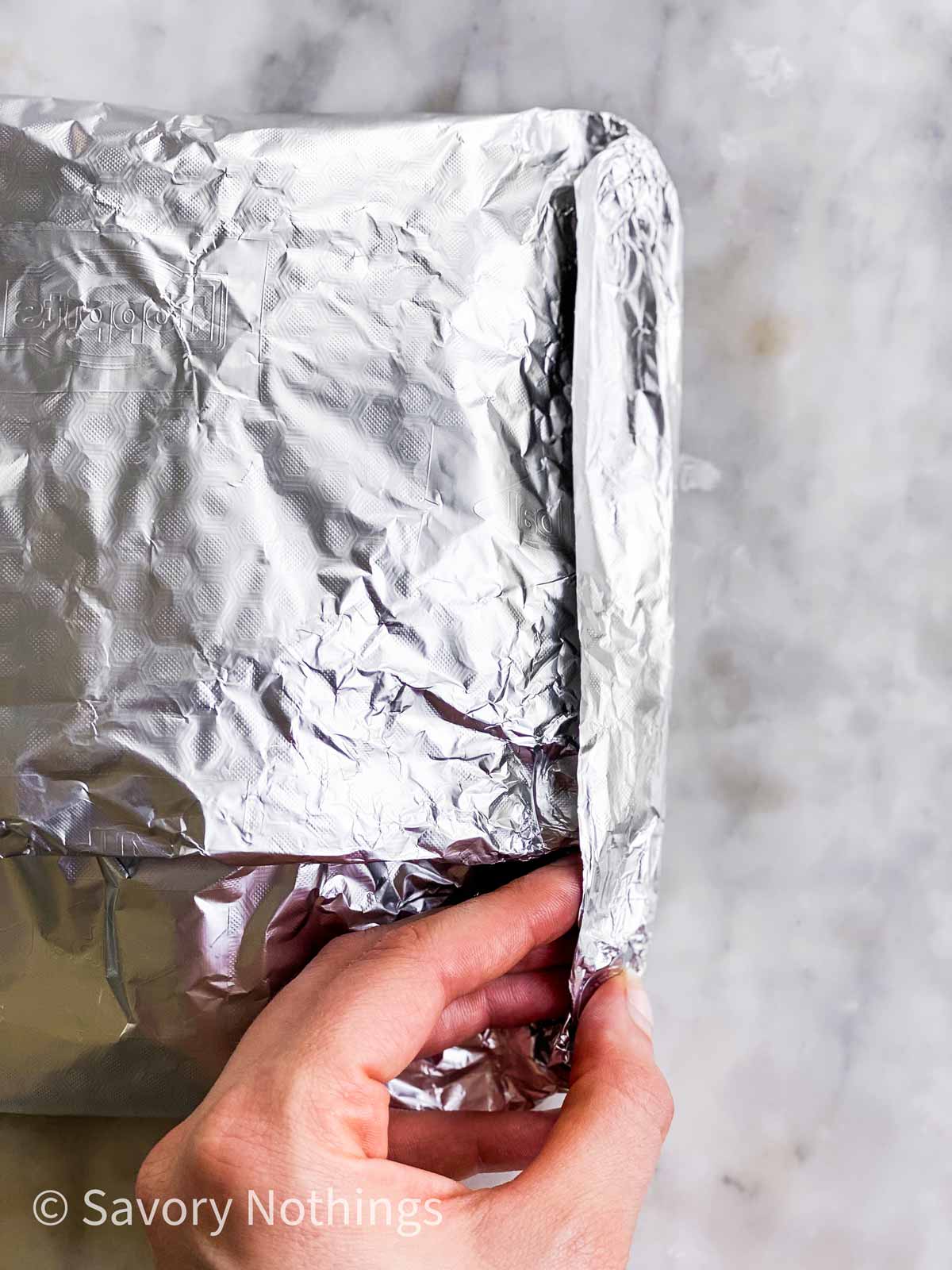 female hand sealing edge of foil packet