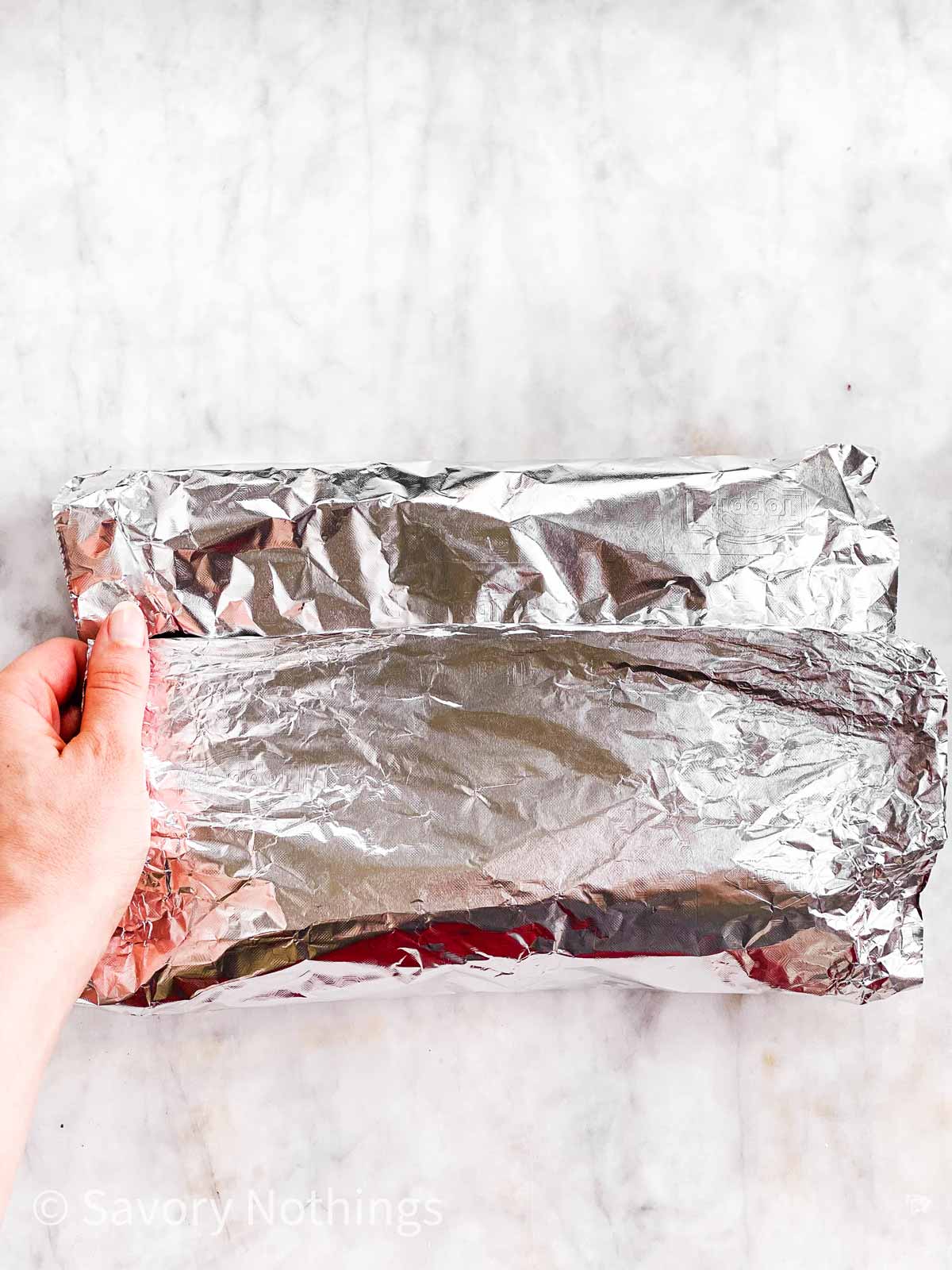 female hands folding down top of foil packet