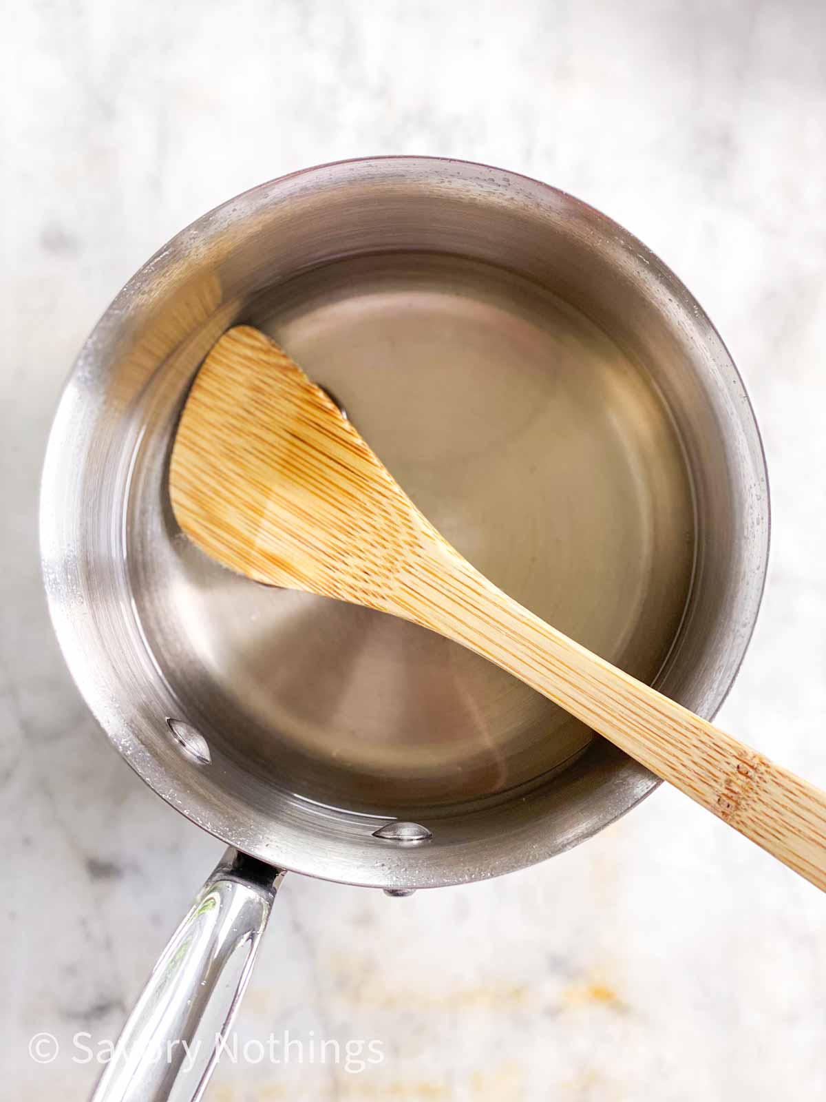 sugar syrup in saucepan with wooden spoon