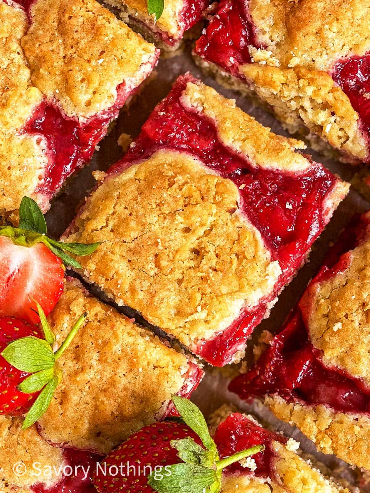 overhead close up view of sliced strawberry oatmeal bars garnished with fresh strawberries