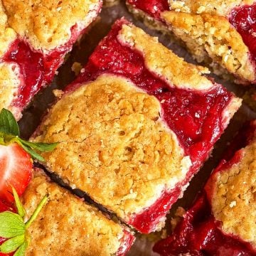 overhead close up view of sliced strawberry oatmeal bars garnished with fresh strawberries
