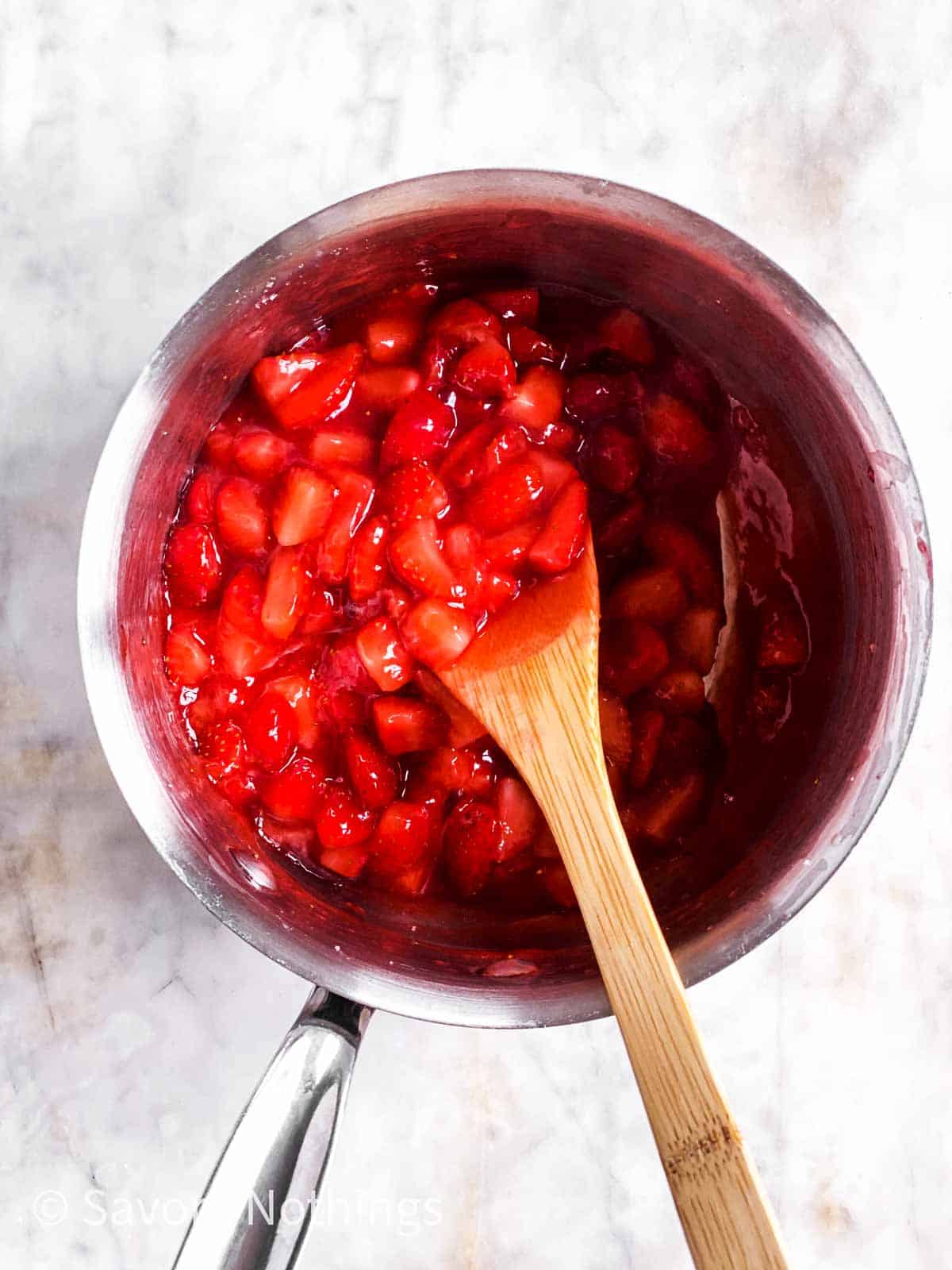 strawberry filling in small saucepan with wooden spoon
