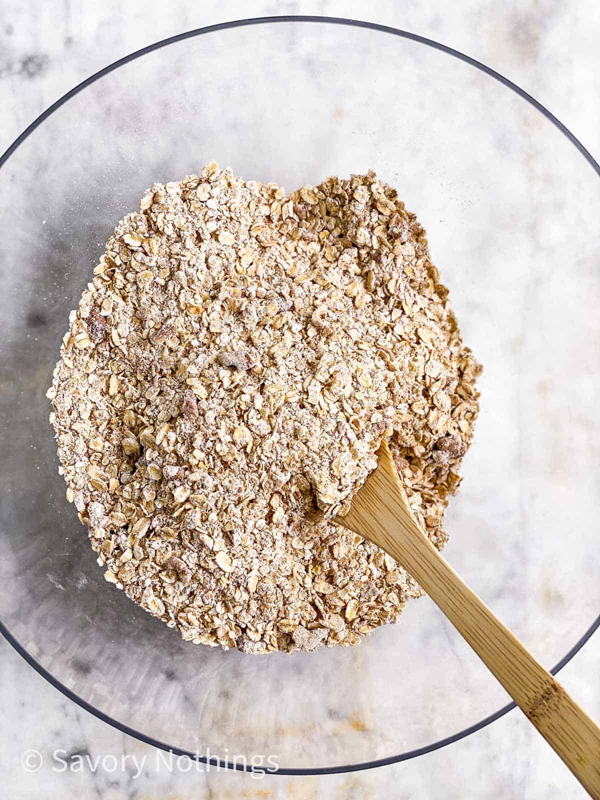 dry ingredients for breakfast cookies in glass bowl with wooden spoon