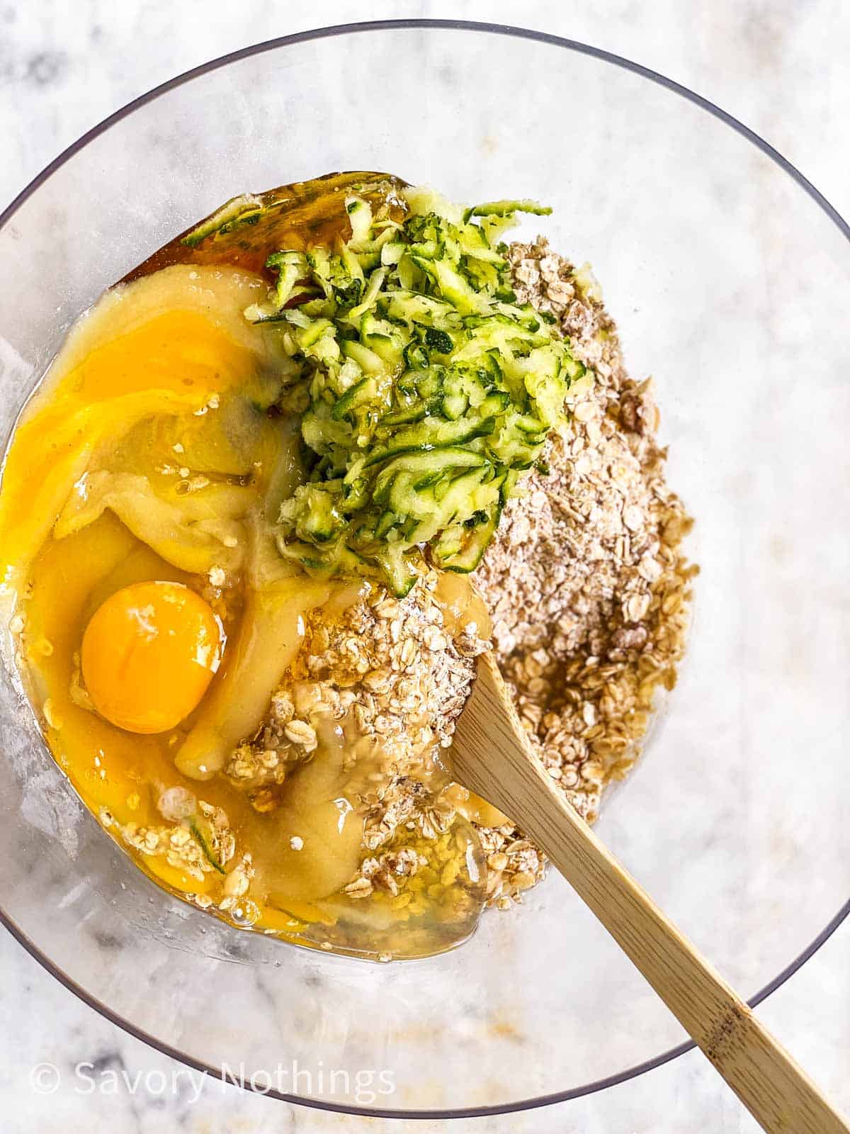 ingredients for breakfast cookie dough in glass bowl with wooden spoon