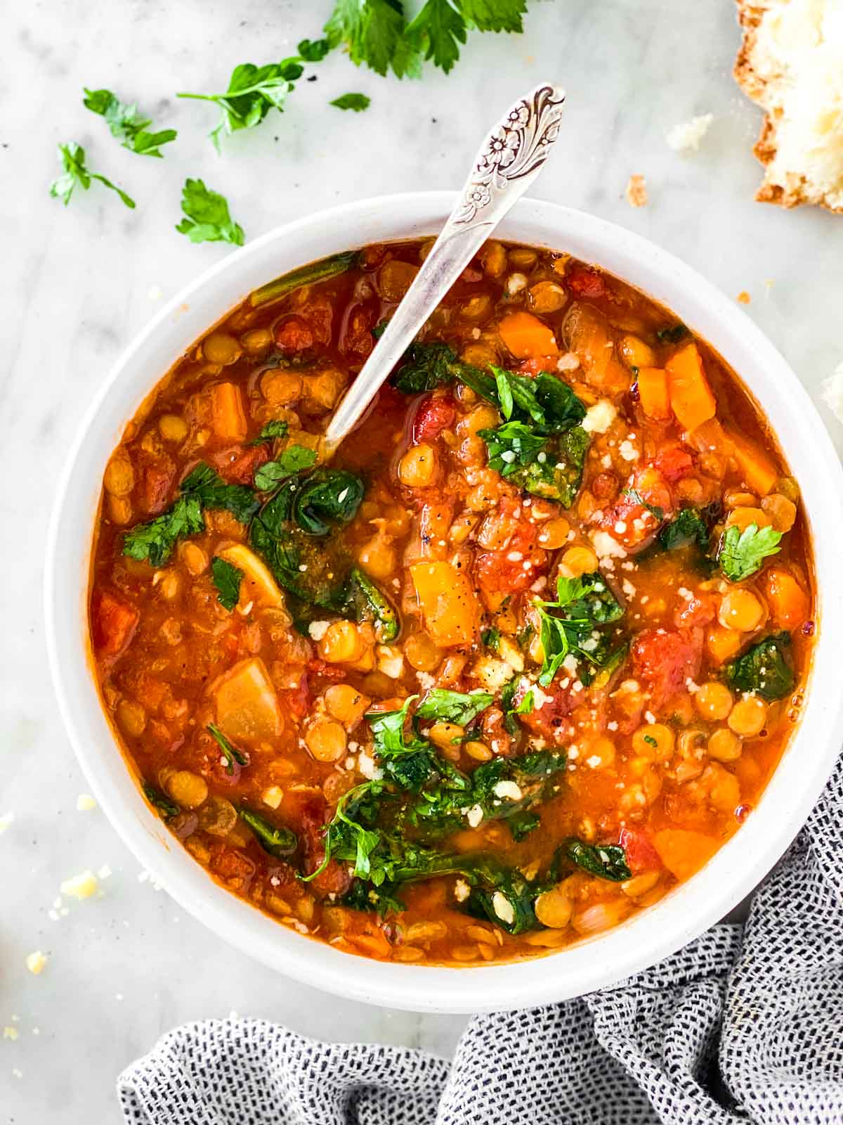 Overhead view of instant pot lentil soup in white bowl sitting on marble surface