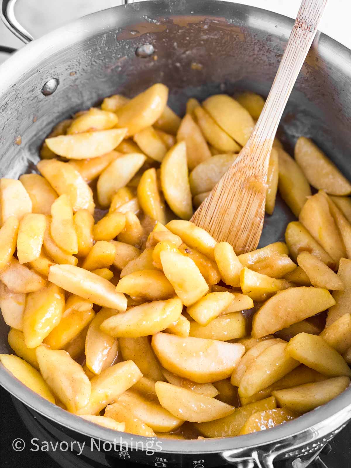 finished apple pie filling in skillet with wooden spoon