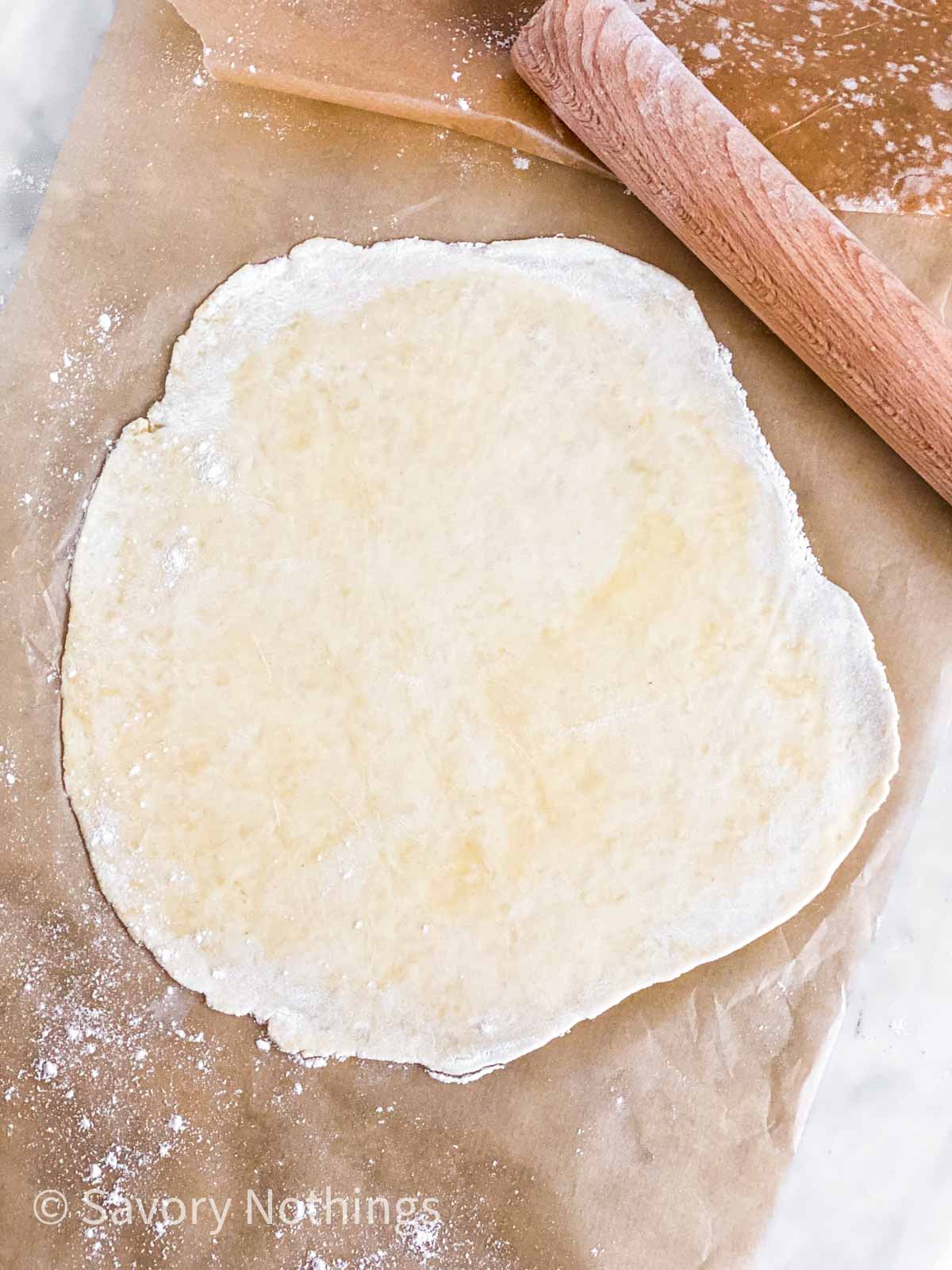 rolled out pie crust on parchment paper