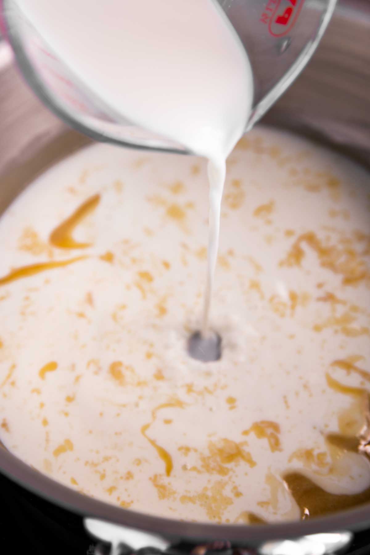 milk pouring into pan with roux