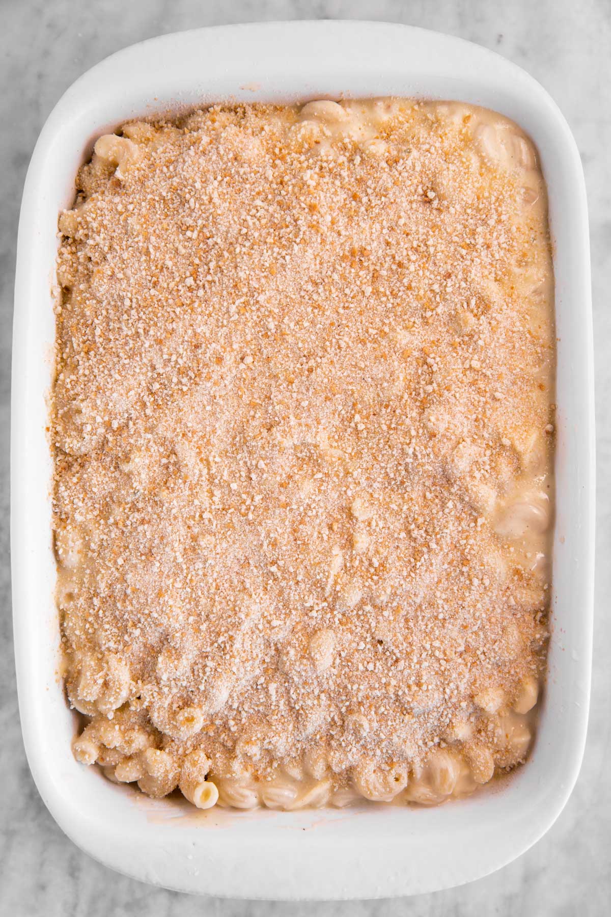 unbaked mac and cheese in white casserole dish