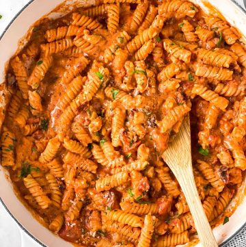 overhead view of white Dutch oven filled with creamy tomato pasta