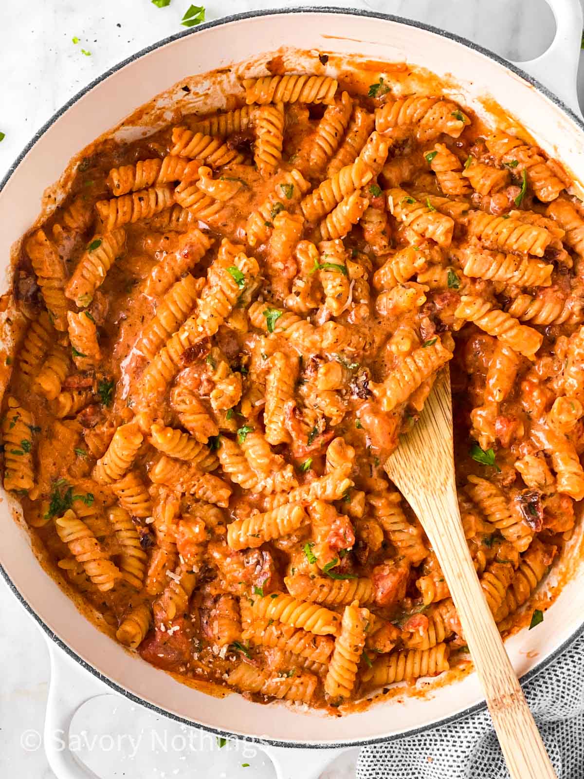 overhead view of white Dutch oven filled with creamy tomato pasta