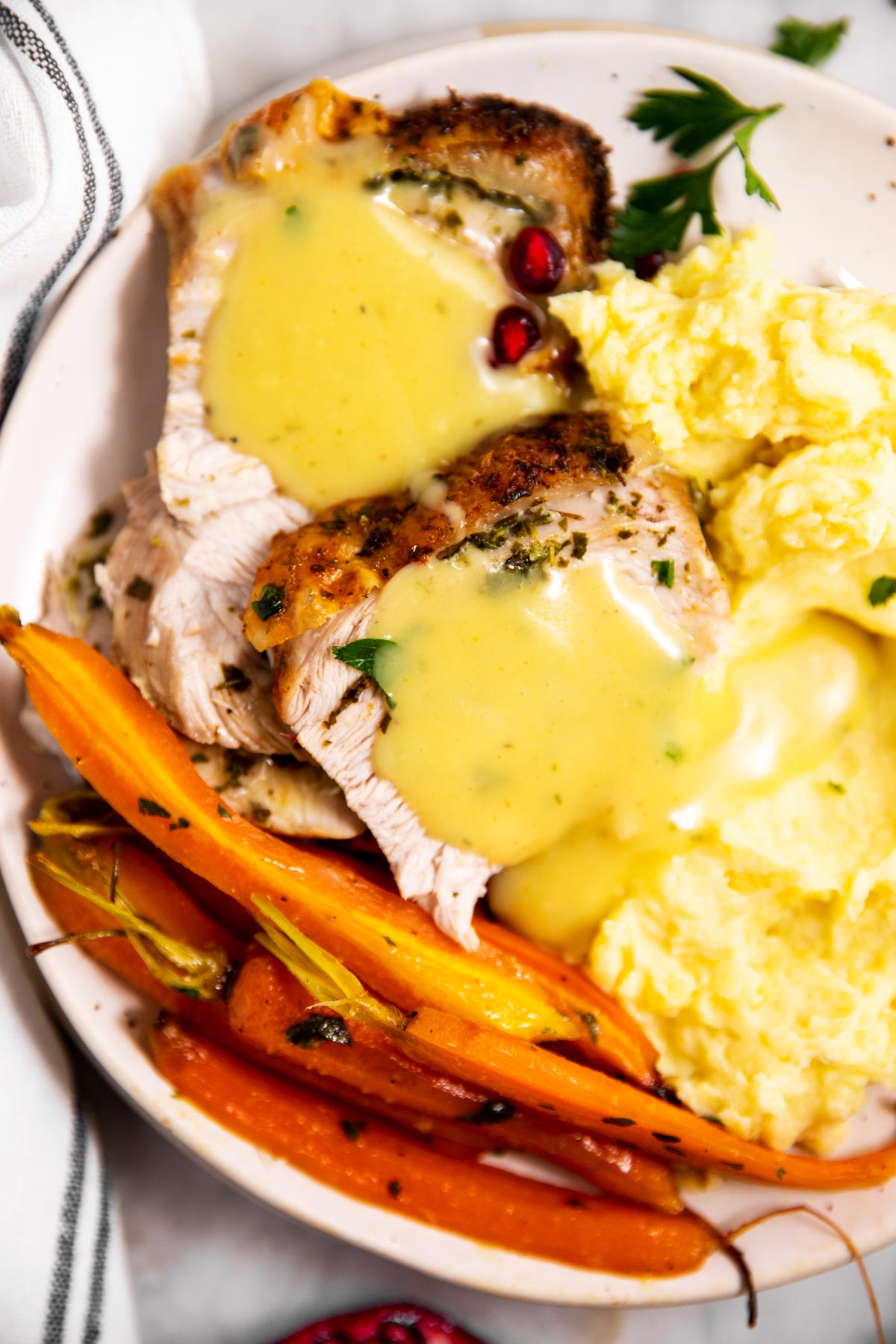 overhead view of gravy smothered turkey breast on plate with mashed potatoes and carrots