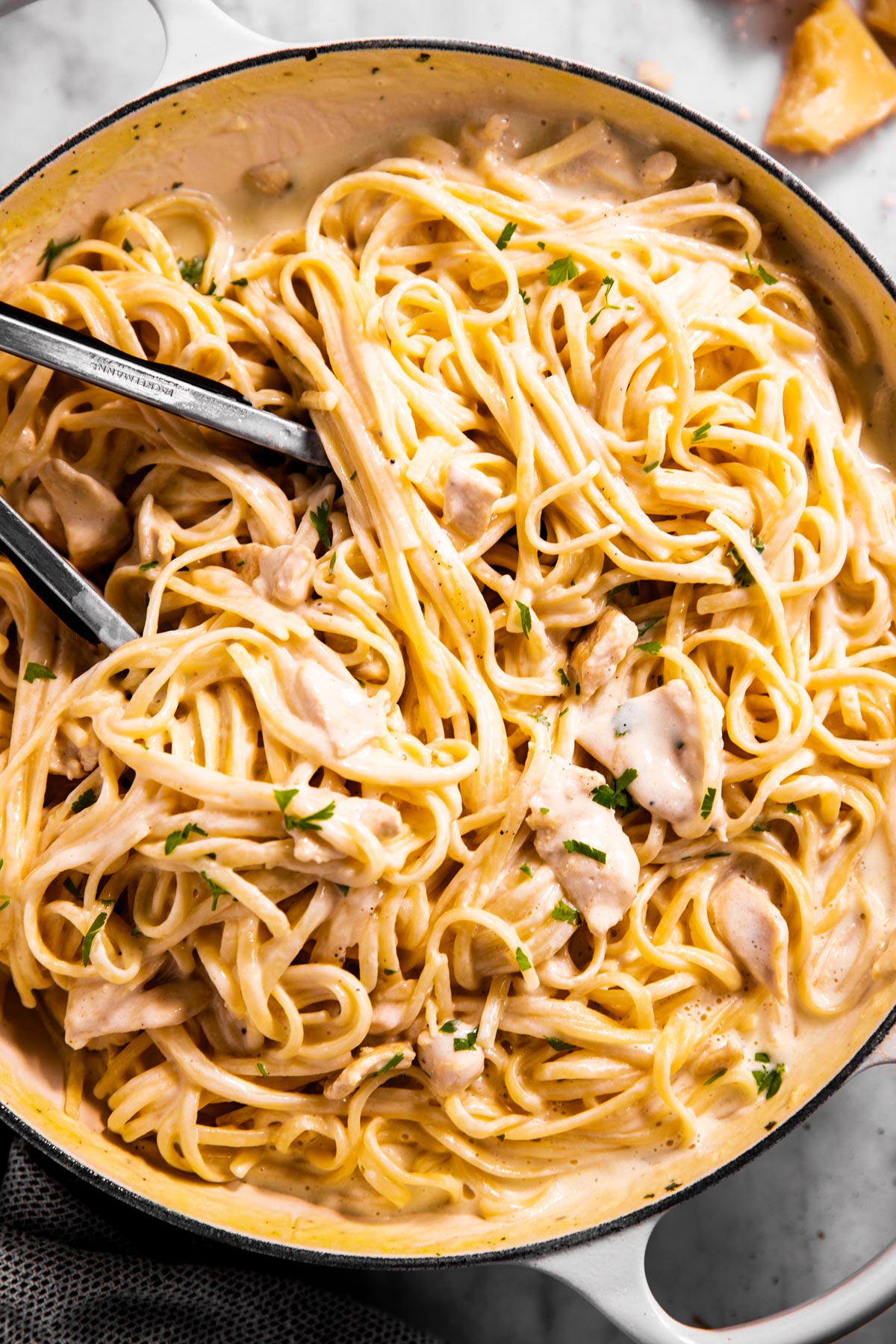 overhead view of chicken fettuccine alfredo in white enamel skillet