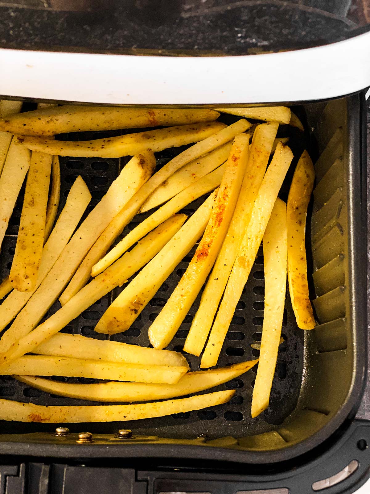 uncooked fries in air fryer basket