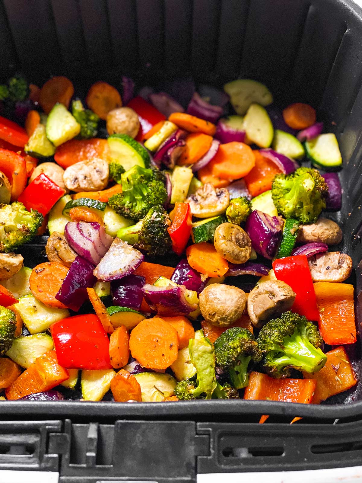 frontal view of air fryer vegetables in air fryer basket